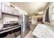 Modern kitchen with stainless steel appliances, gray cabinets, and views into the dining area at 6310 Lake Underhill Rd, Orlando, FL 32807