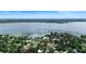 Aerial view highlighting a beautiful lakefront property with lush greenery and a luxurious Mediterranean-style house at 65 Oakdale St, Windermere, FL 34786