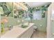 Unique bathroom with tropical wallpaper, retro tiling, and a large vanity at 65 Oakdale St, Windermere, FL 34786