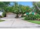Charming home with a well-maintained lawn, mature trees, and a spacious driveway leading to a two-car garage at 65 Oakdale St, Windermere, FL 34786
