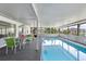 Inviting indoor pool area with a dining set, offering a relaxing space with scenic views at 65 Oakdale St, Windermere, FL 34786