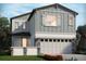 Charming two-story home featuring light-blue siding, stone accents, a two-car garage and lush landscaping at 651 Pennywort St, Lake Alfred, FL 33850