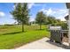 Spacious backyard featuring a well-kept lawn, mature trees, and outdoor grill at 827 Grandin St, Davenport, FL 33837