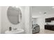 Half bath featuring a modern vessel sink, oval mirror, and view into the adjacent living area at 827 Grandin St, Davenport, FL 33837