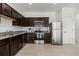 Modern kitchen with dark cabinetry, granite countertops, and stainless steel appliances at 827 Grandin St, Davenport, FL 33837