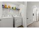 Laundry room with washer, dryer, wire rack shelving, and neutral walls at 827 Grandin St, Davenport, FL 33837