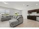 Comfortable living room with large gray sectional, kitchenette, and sliding glass door to outdoor at 827 Grandin St, Davenport, FL 33837