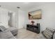 Living room with plank flooring, TV, media center, and comfortable gray seating at 827 Grandin St, Davenport, FL 33837