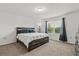 Bright main bedroom featuring a queen-size bed, ample natural light, and neutral decor at 827 Grandin St, Davenport, FL 33837