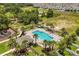 Aerial view of a sparkling community pool surrounded by lush landscaping and lounging areas at 827 Grandin St, Davenport, FL 33837