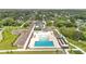 An aerial view reveals a pool, playground, and modern building surrounded by extensive parking at 900 Northern Dancer Way # 204, Casselberry, FL 32707