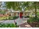 Charming building with mosaic accents, red door, and lush landscaping around the front entrance at 900 Northern Dancer Way # 204, Casselberry, FL 32707