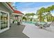 Relaxing community pool with a covered patio area, tables, chairs and multiple palm trees at 900 Northern Dancer Way # 204, Casselberry, FL 32707