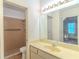Functional bathroom featuring tiled shower, toilet, and large vanity mirror at 901 Illinois Ave, St Cloud, FL 34769