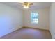 Cozy bedroom with neutral carpet, ceiling fan, and natural light from the window at 901 Illinois Ave, St Cloud, FL 34769