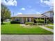 Charming brick home featuring a well-maintained lawn, lush landscaping, and welcoming front entrance at 901 Illinois Ave, St Cloud, FL 34769