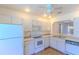 This kitchen features standard white appliances and a cutout to the living area at 901 Illinois Ave, St Cloud, FL 34769