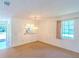 A carpeted living room area that connects to another room at 901 Illinois Ave, St Cloud, FL 34769