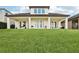 Expansive backyard view of home featuring covered porch and manicured lawn at 9207 Busaco Park Way, Winter Garden, FL 34787