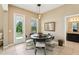 Bright dining area featuring a round table and chairs with an adjacent view of the outdoors and access to the bathroom at 9207 Busaco Park Way, Winter Garden, FL 34787