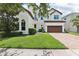 Charming two-story stucco home featuring a tile roof, well-manicured lawn and attached two-car garage at 9207 Busaco Park Way, Winter Garden, FL 34787