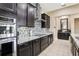 Well-equipped kitchen with stainless steel oven, dark cabinets, granite countertops, and tile backsplash at 9207 Busaco Park Way, Winter Garden, FL 34787