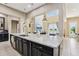 Spacious kitchen island with bar seating, pendant lights, and views of the fireplace and pond at 9207 Busaco Park Way, Winter Garden, FL 34787