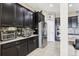 Modern kitchen featuring dark cabinets, stainless steel appliances, and tile backsplash at 9207 Busaco Park Way, Winter Garden, FL 34787