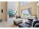 Open-concept living room with a stone fireplace, tile floors, furniture, and pond views at 9207 Busaco Park Way, Winter Garden, FL 34787