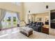Bright living room with high ceilings, tile floors, furniture, and large windows overlooking the pond at 9207 Busaco Park Way, Winter Garden, FL 34787