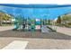 Community playground with climbing structures and slides with protective canopy and soft ground cover at 9207 Busaco Park Way, Winter Garden, FL 34787