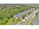 Aerial view of gray townhomes with a wooded area, landscaped lawns, and close proximity to each other at 976 Rock Harbor Ave, Orlando, FL 32828