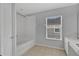 Clean bathroom with tub and shower, single sink vanity, and window at 976 Rock Harbor Ave, Orlando, FL 32828