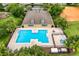 Aerial view of the community pool with lounge chairs, surrounding landscaping, and building at 9966 Hidden Dunes Ln, Orlando, FL 32832