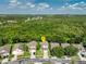 Aerial view of a charming two-story home with lush green lawn surrounded by many trees at 9966 Hidden Dunes Ln, Orlando, FL 32832
