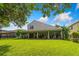 Expansive backyard showcasing a large covered patio, mature trees, and an iron fence at 9966 Hidden Dunes Ln, Orlando, FL 32832