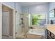 This bathroom features a stand up shower, soaking tub, tile surround, and glass door at 9966 Hidden Dunes Ln, Orlando, FL 32832