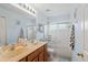 Bathroom featuring a double vanity, tiled shower, and plenty of light at 9966 Hidden Dunes Ln, Orlando, FL 32832