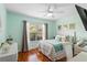 Comfortable bedroom with hardwood floors, light blue walls, dresser, and window with neutral curtains at 9966 Hidden Dunes Ln, Orlando, FL 32832