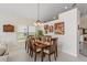 Dining room with a wooden table, chairs, decorative lighting, and a window providing natural light at 9966 Hidden Dunes Ln, Orlando, FL 32832