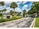 Gated community entrance with lush landscaping and mature palm trees at 9966 Hidden Dunes Ln, Orlando, FL 32832
