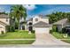 Charming two-story home with lush green lawn, landscaped garden, and attached two-car garage at 9966 Hidden Dunes Ln, Orlando, FL 32832