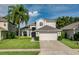 Traditional two-story home with a two-car garage, well-manicured lawn, and mature landscaping at 9966 Hidden Dunes Ln, Orlando, FL 32832