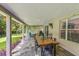 The covered outdoor patio has a large wooden table and chairs, with a ceiling fan and view of the landscaped yard at 9966 Hidden Dunes Ln, Orlando, FL 32832
