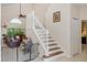 Staircase with white railing, wood steps, high ceilings, and a view into the living room at 9966 Hidden Dunes Ln, Orlando, FL 32832
