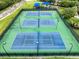 Aerial view of community tennis courts surrounded by fences and trees at 9966 Hidden Dunes Ln, Orlando, FL 32832