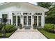 Building exterior with multiple windows, black lanterns, potted plants, and low hedge around the patio at 1011 Lake Davis Dr, Orlando, FL 32806