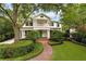 Elegant two-story home with lush landscaping, a brick walkway, and a covered porch, showcasing curb appeal at 1011 Lake Davis Dr, Orlando, FL 32806