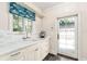 Bright, classic kitchen area with a white marble countertop, window, sink, and ample cabinet space at 1011 Lake Davis Dr, Orlando, FL 32806