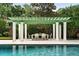 Stylish poolside pergola with an outdoor dining set, perfect for entertaining and enjoying the backyard scenery at 1011 Lake Davis Dr, Orlando, FL 32806